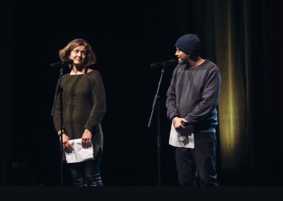 Zwei Menschen auf einer Bühne schauen sich an